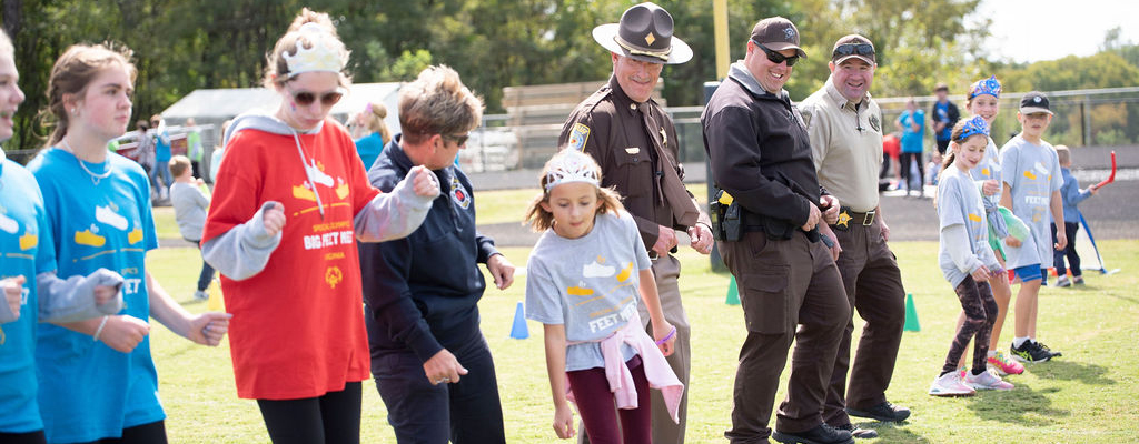 Officers dance with kids at Little Feet Meet at Liberty High SChool